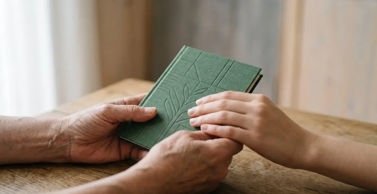 Gros plan sur des mains tenant un carnet d'épargne symbolisant la stratégie financière familiale
